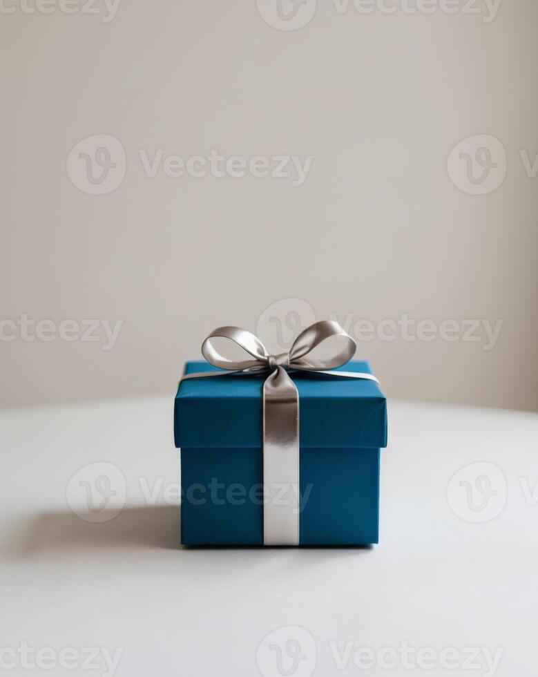 A blue gift box with a silver bow on top. photo