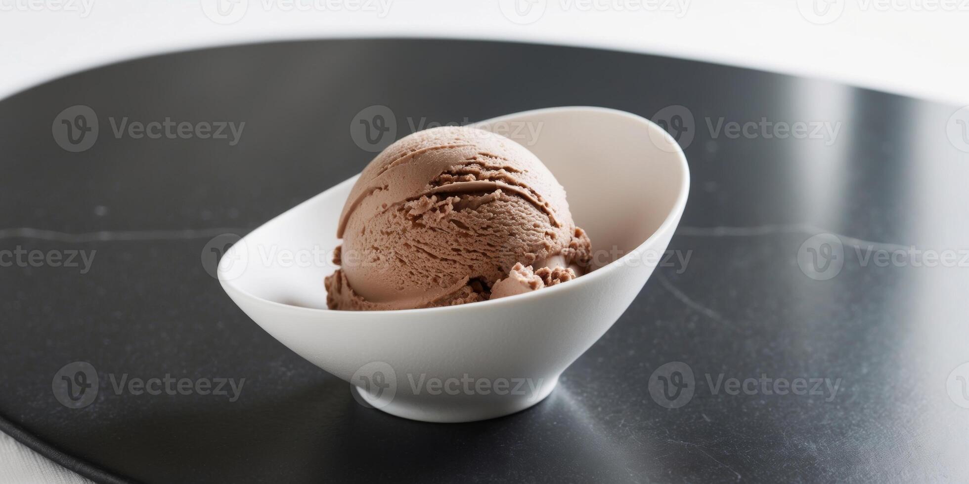 Chocolate hazelnut ice cream in a bowl on sleek black stone surface. photo