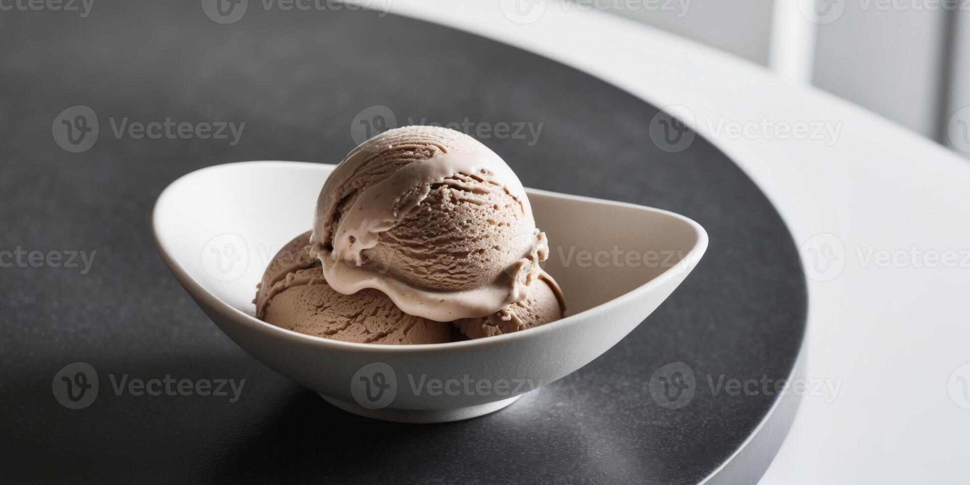 Chocolate hazelnut ice cream in a bowl on sleek black stone surface. photo