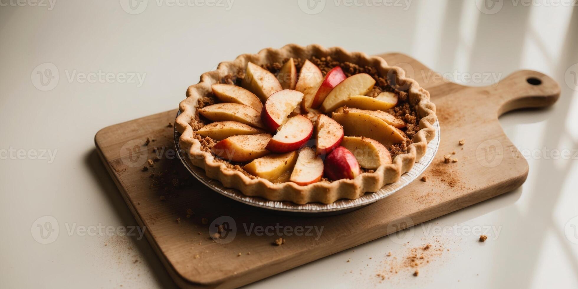 A pie with apples and crumbs on a wooden cutting board. photo