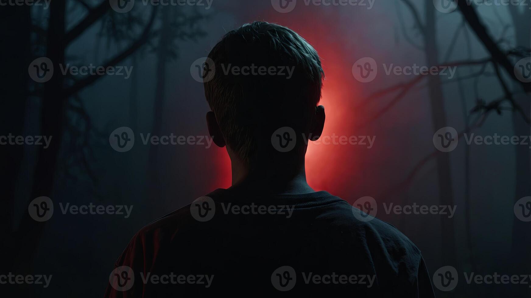 A man in the dark with a red light shining on him photo