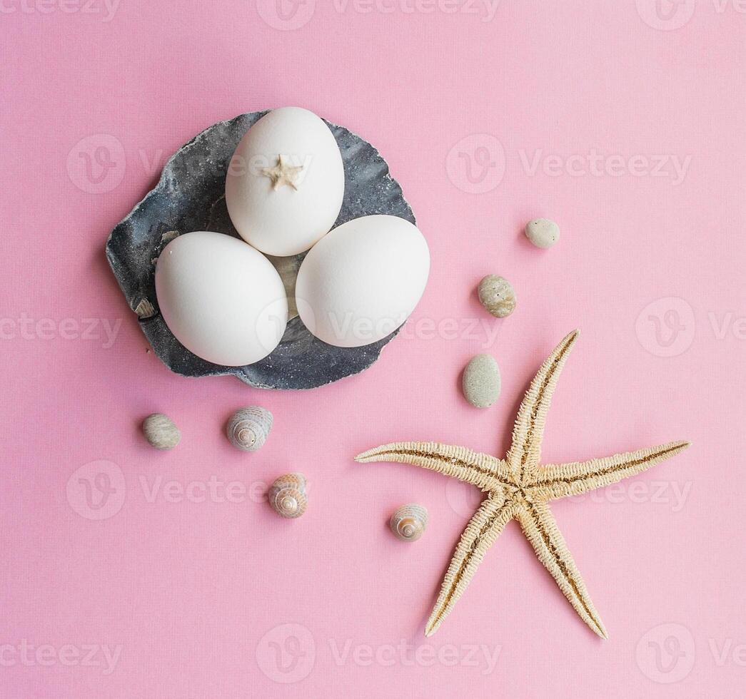 White eggs in an Easter composition with starfish and sticks from the sea photo