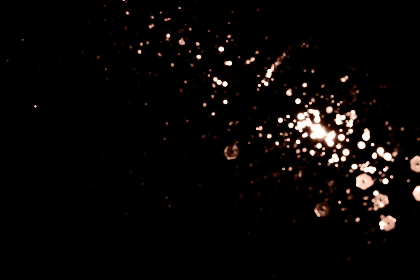 Blurry garland lights on a dark background. Festive Christmas and New Year background. Soft focus. Image toned in color of 2025 year - Mocha Mousse photo