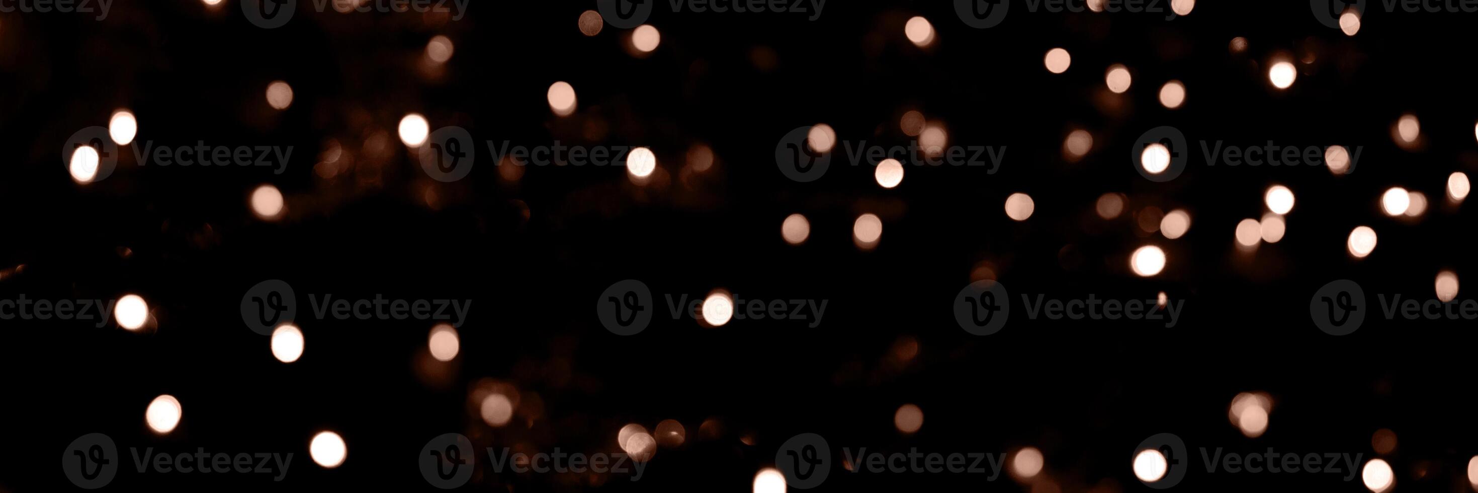 Blurry garland lights on a dark background. Festive Christmas and New Year background. Soft focus. Image toned in color of 2025 year - Mocha Mousse photo