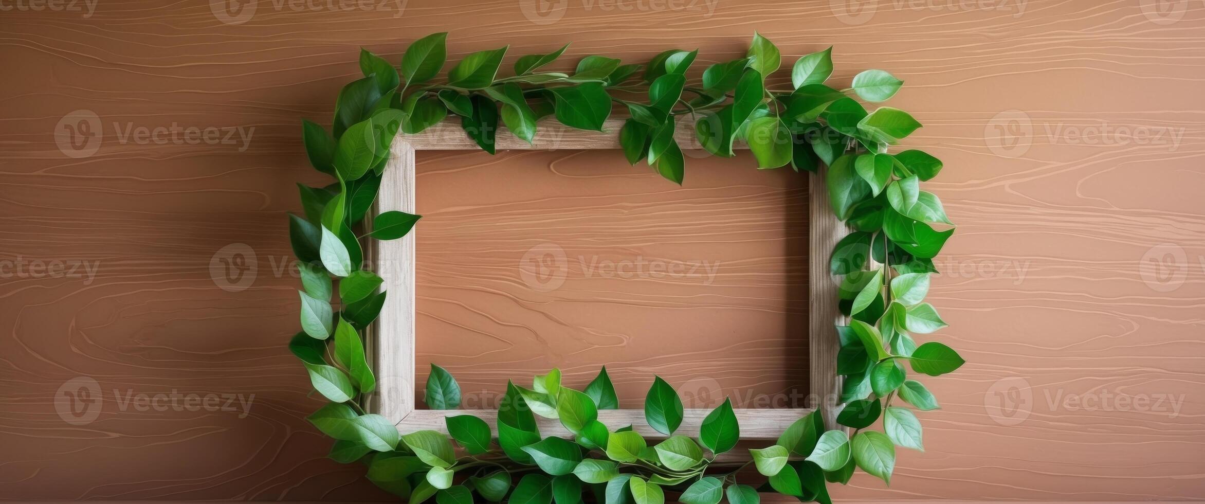 A frame with green leaves on a brown wall photo