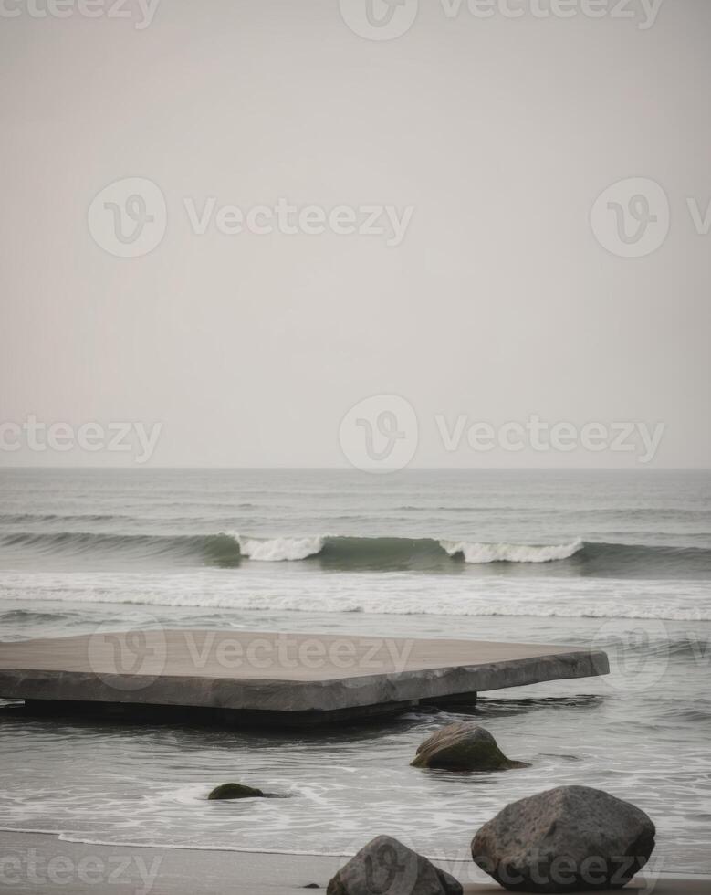 A pier with rocks and a surfboard in the water photo