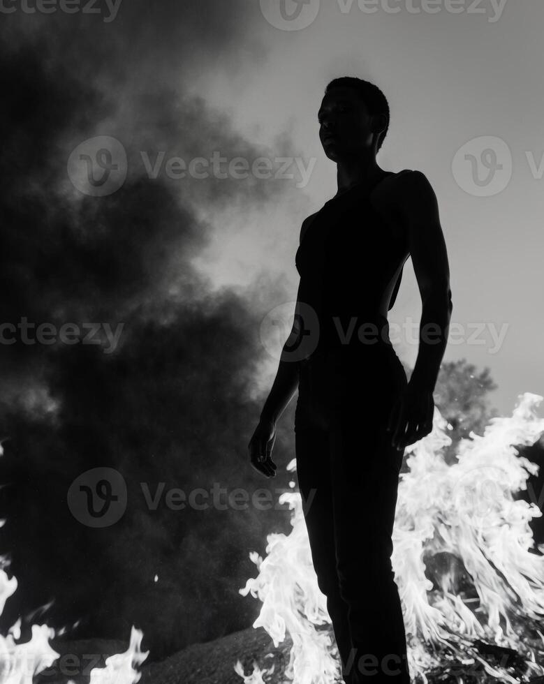 A woman standing in front of a fire photo