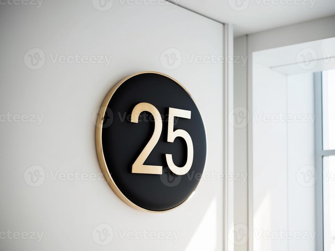 A black and gold number 25 sign on a white wall photo