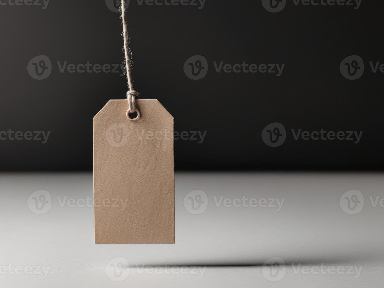 Blank blank price tag hanging from a string on a black background photo