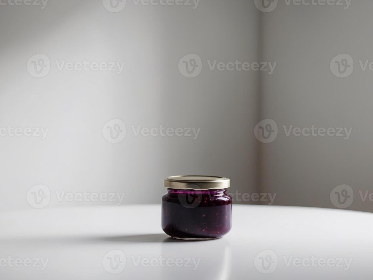 A jar of blueberry jam on a white table photo