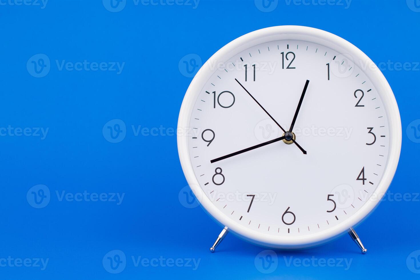 Clock telling time and working on time photo in studio on blue background