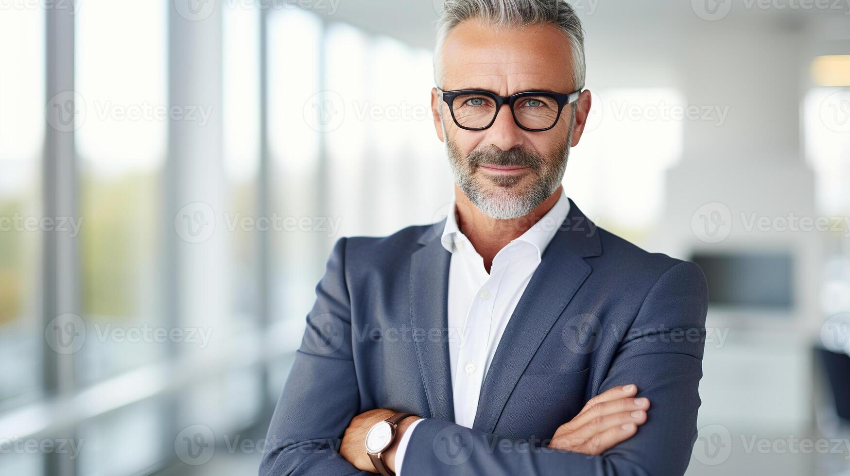 A man in a suit and glasses standing in an office photo