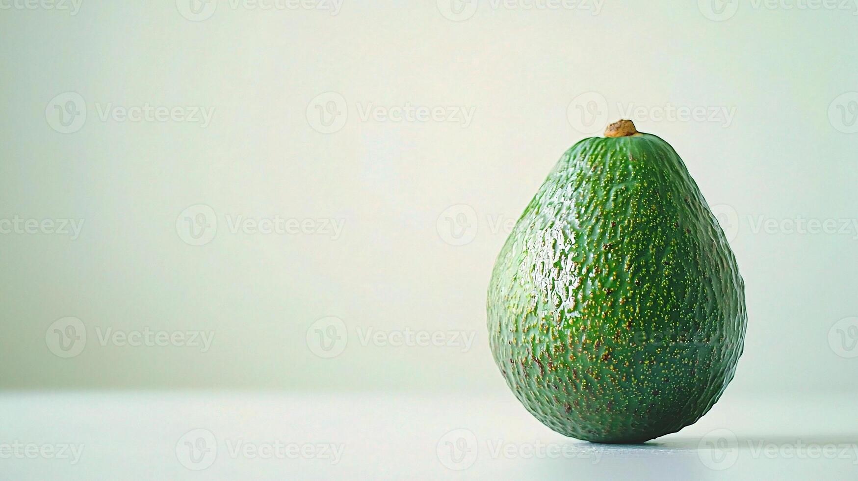 A single avocado on a white surface photo