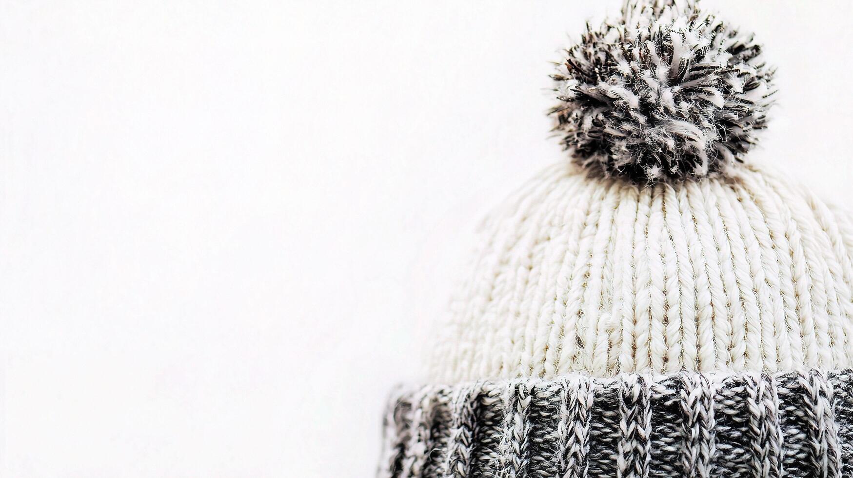 A close up of a knitted hat with a pom pom photo