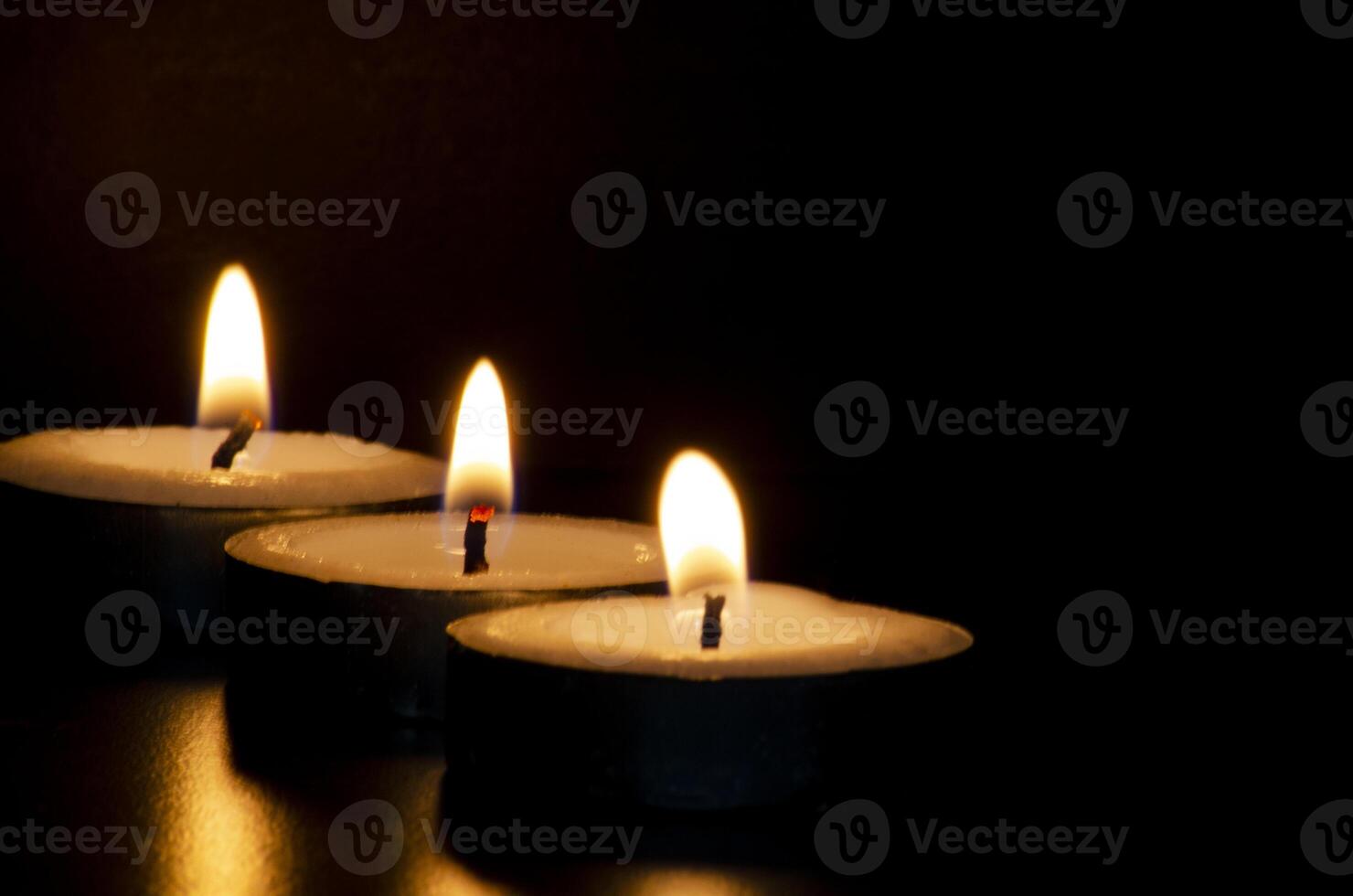 Candles shining in the dark representing religious prayer moment with customizable space for message, text or ideas. photo