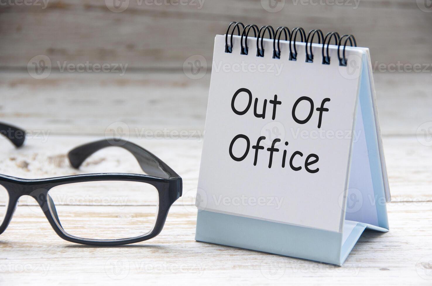 Side view of Out Of Office text on white notepad. Off work concept photo