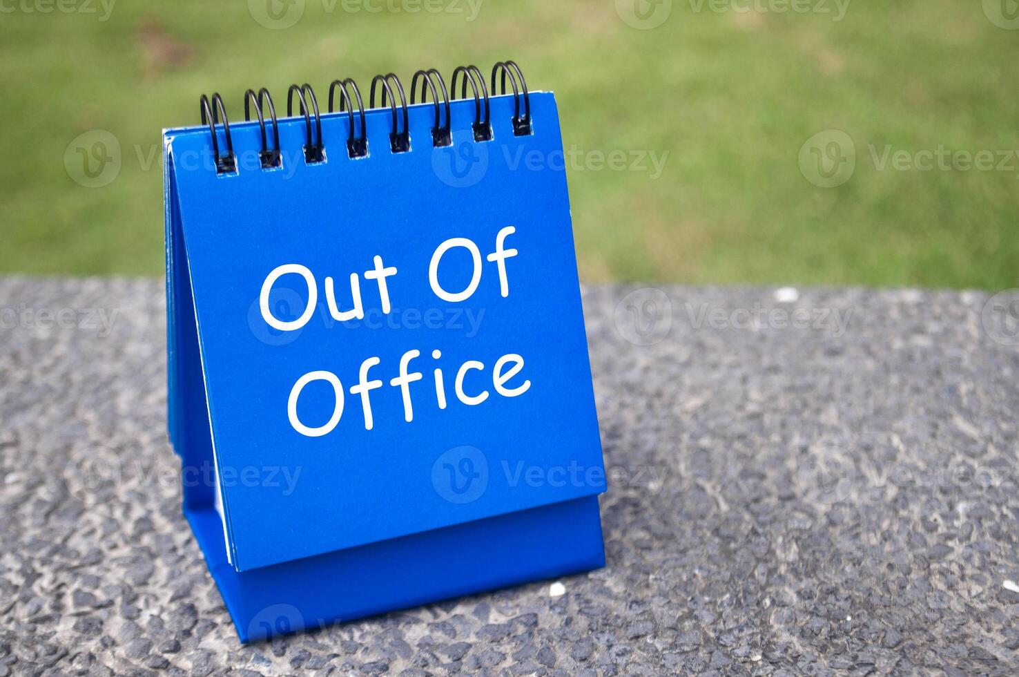 Side view of Out Of Office text on blue notepad. Off work concept photo