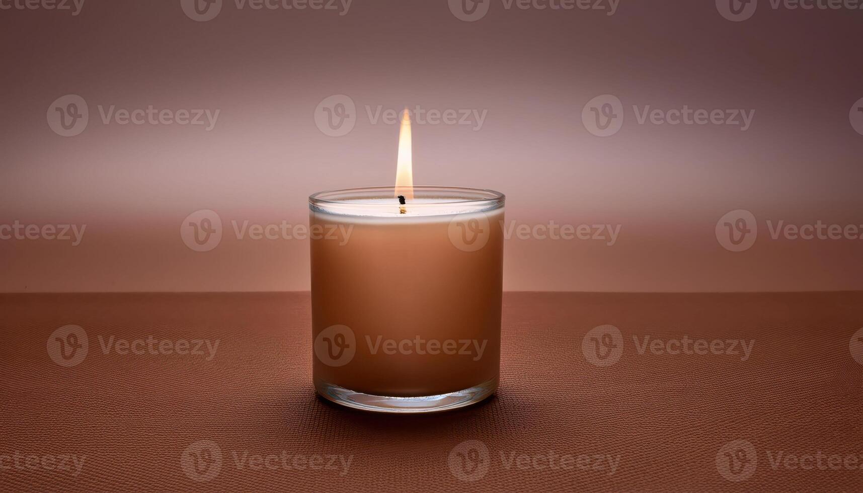 Lit beige candle on brown surface with soft glow, mocha mousse color photo