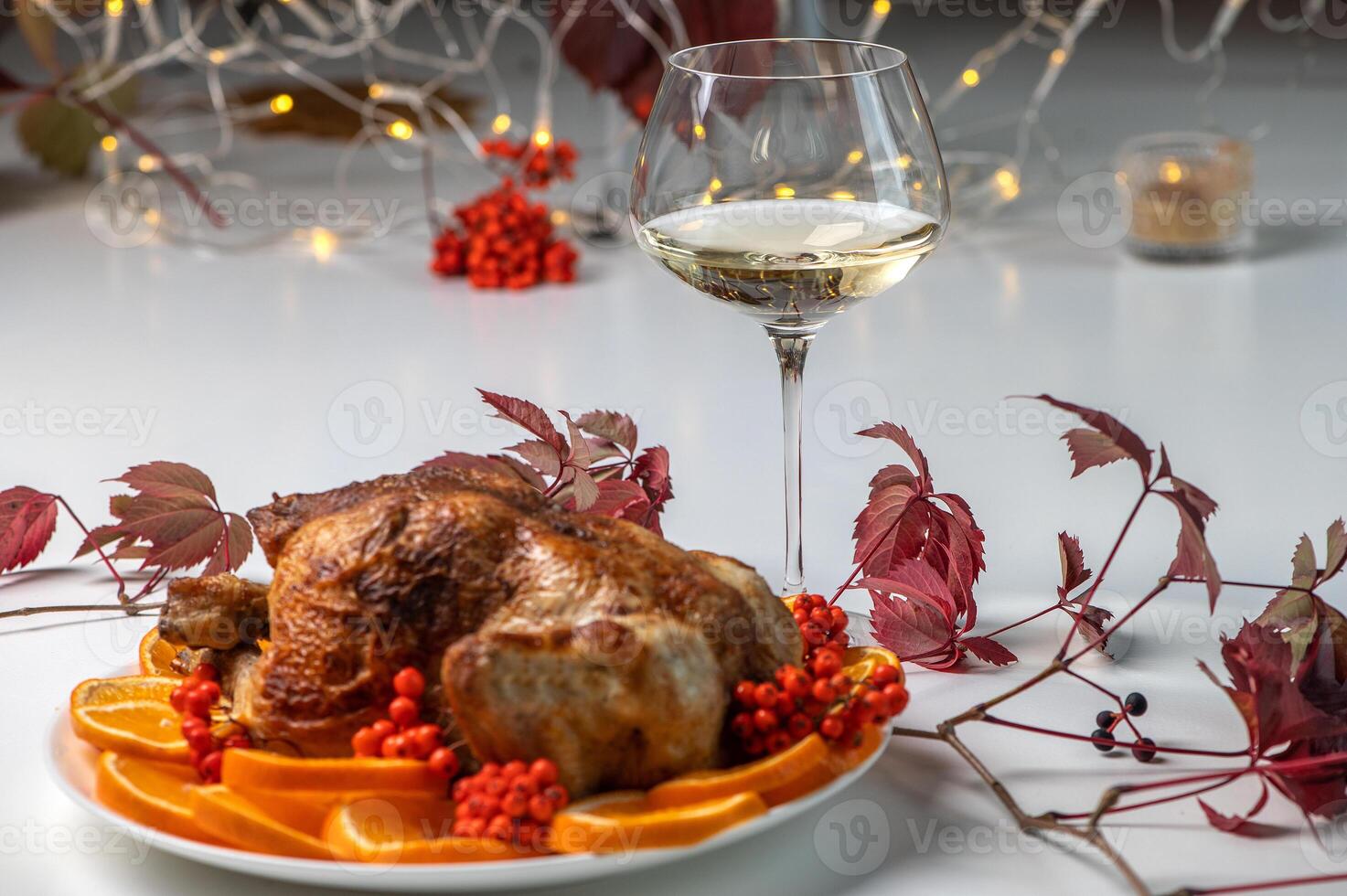 Thanksgiving roast turkey decorated with orange slices and rowan berries, bokeh background photo