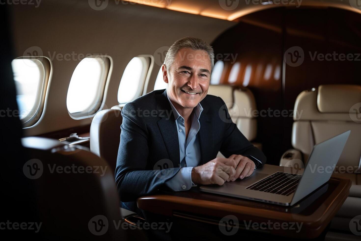Handsome smiling businessman in suit looking at camera while sitting in private plane photo