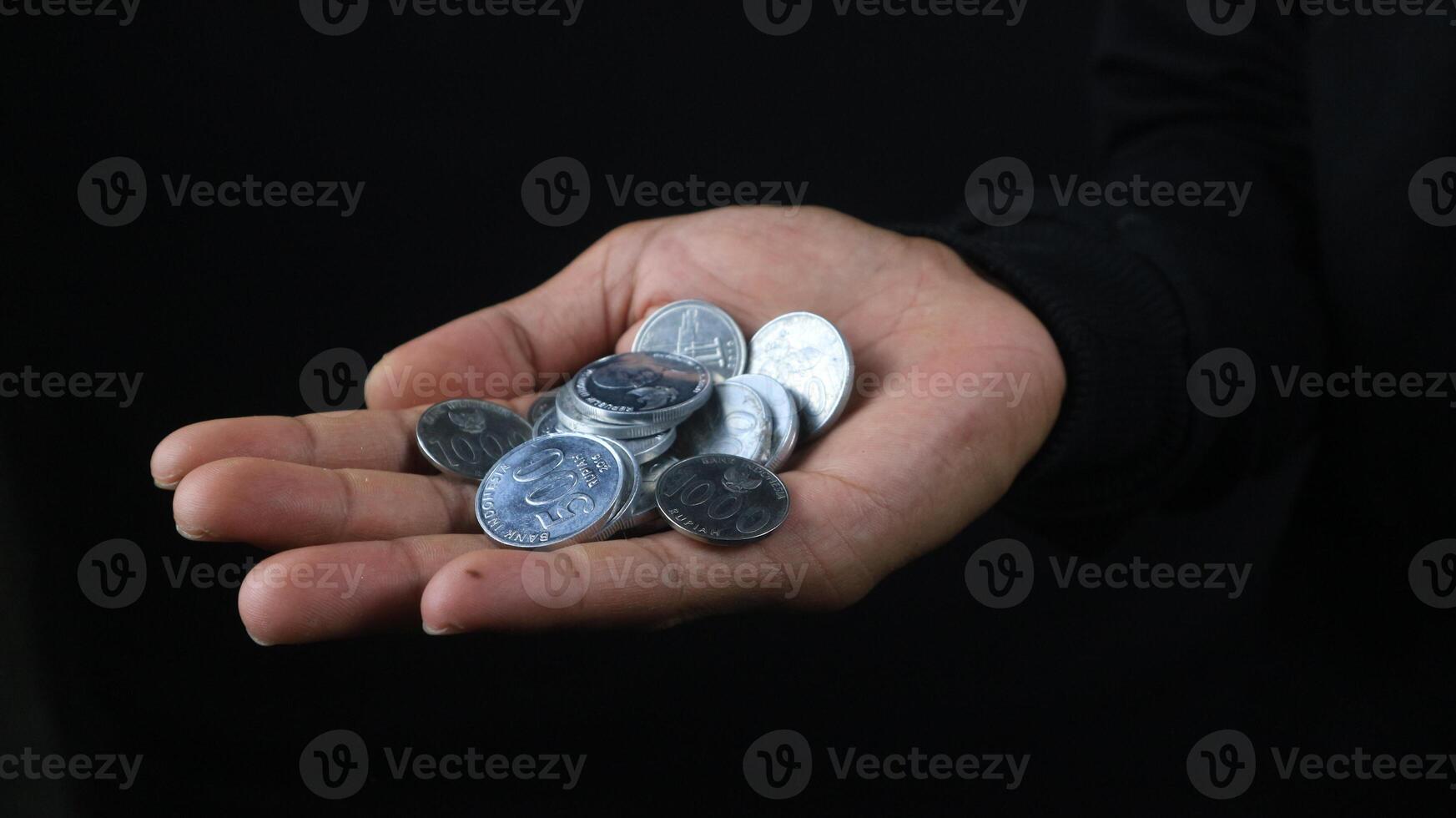 Close up of male hands holding Indonesian coins, savings and banking concept photo