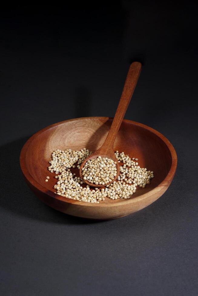 White peper in wooden bowl isolated on black background. High resolution photo. photo