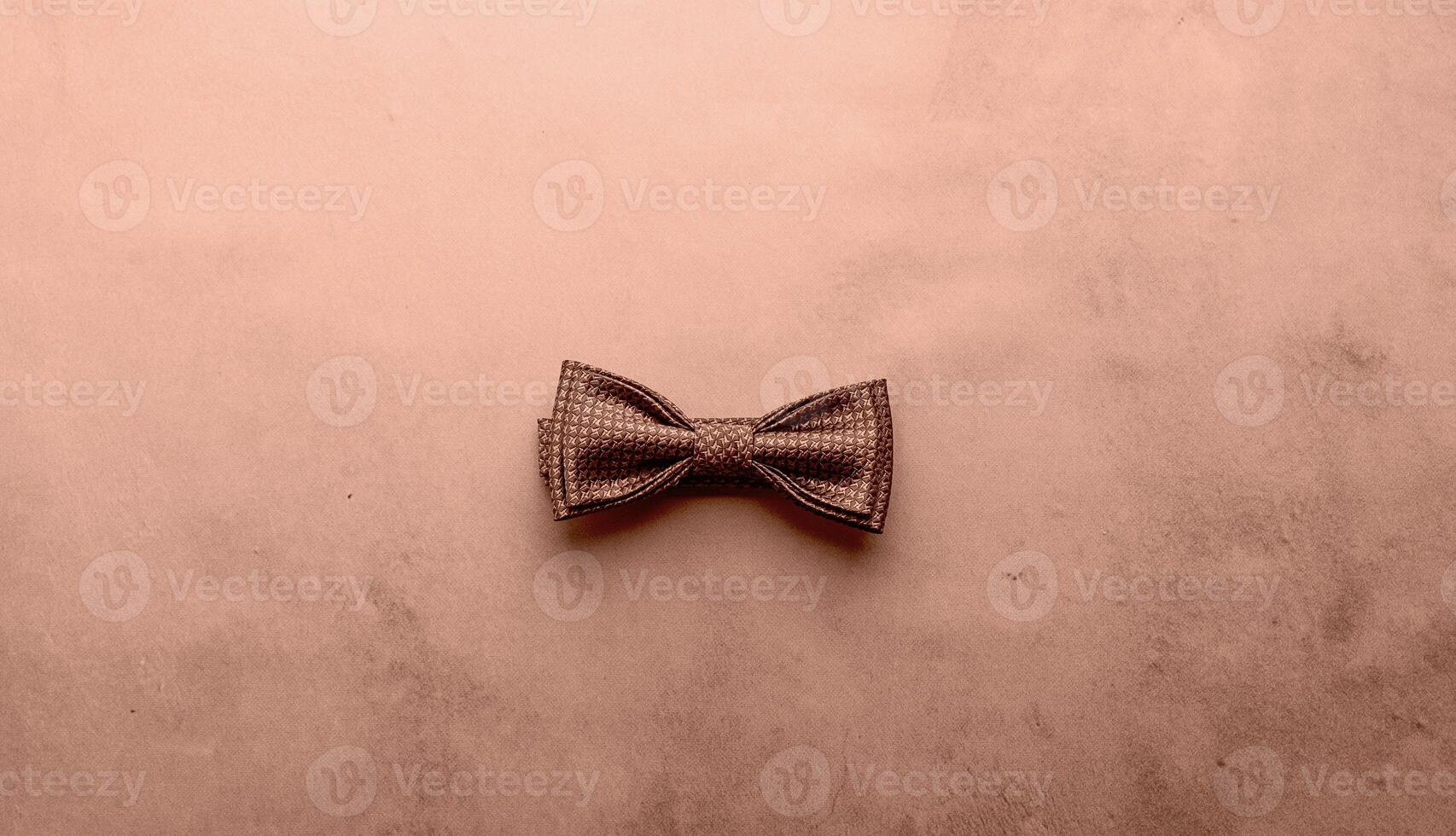 Elegant brown textured bow tie on minimalist background photo