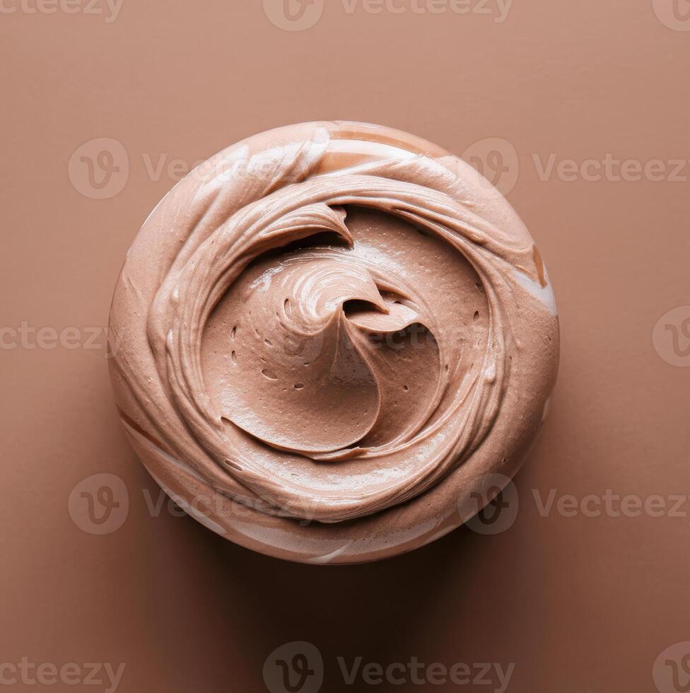 Top view of smooth brown swirled chocolate cream on circular surface photo