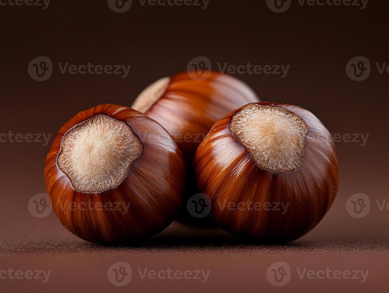 A close up of three hazelnuts on a brown surface photo