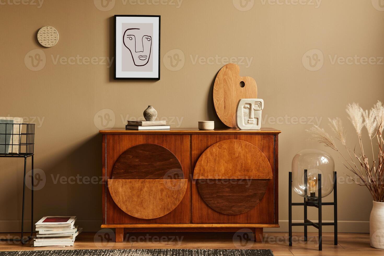 Stylish interior with design wooden commode, lamp, dried flowers in vase, unique decoration, carpet, mock up poster frame and elegant personal accessories. Modern living room in classic house. photo