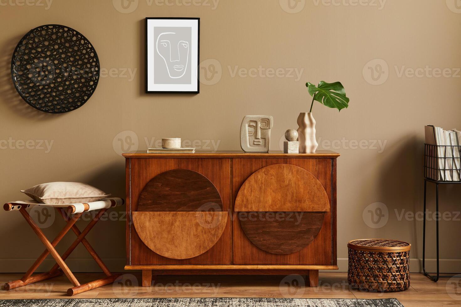 Stylish interior with design wooden commode, stool, dried flowers in vase, unique decoration, carpet, mock up poster frame and elegant personal accessories. Modern living room in classic house. photo