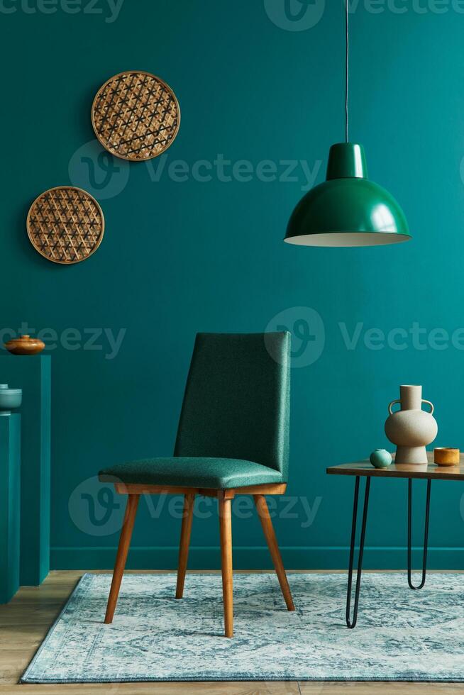 Stylish concept of living room interior with small walnut table, design chairs, tropical leaf in beige vase, clock, retro carpet, decoration and accessories in modern vintage home decor. photo