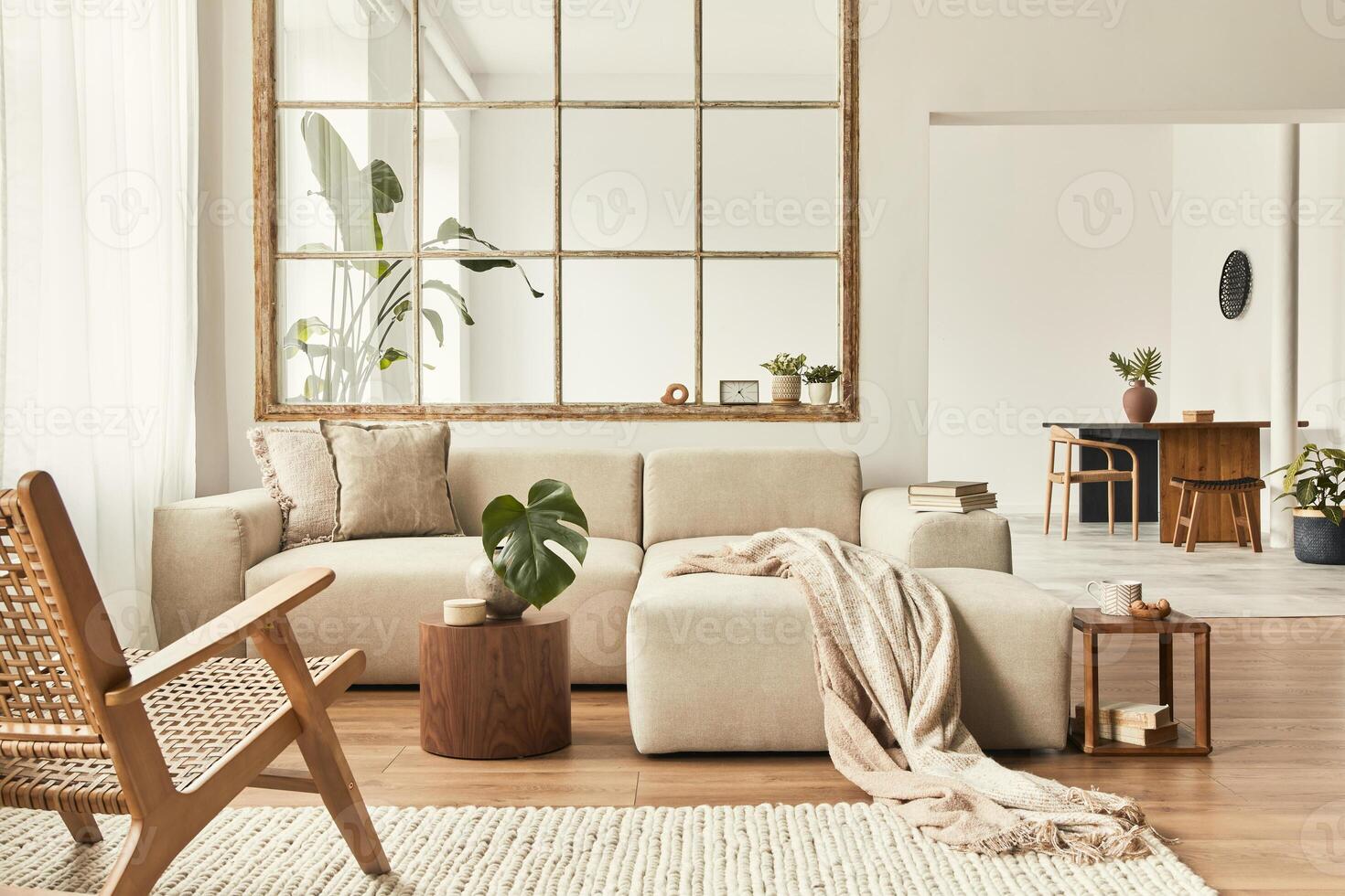 Modern interior of open space with design modular sofa, furniture, wooden coffee tables, plaid, pillows, tropical plants and elegant personal accessories in stylish home decor. Neutral living room. photo
