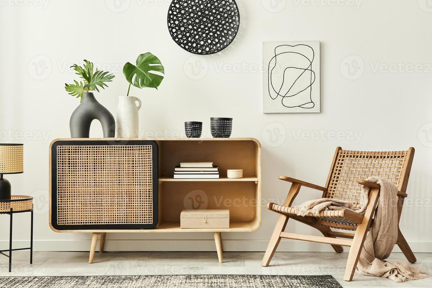 Stylish scandinavian living room interior of modern apartment with wooden commode, design armchair, carpet, leaf in vase, table lamp and personal accessories in unique home decor. Template. photo