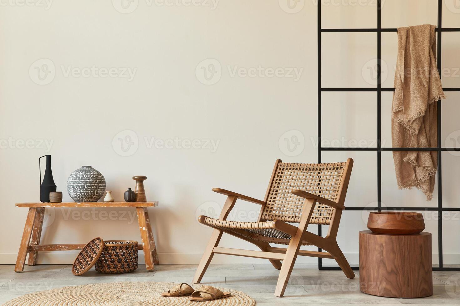 Stylish interior design of living room with wooden armchair, coffee table, bench, rattan decoration, carpet and elegant personal accessories. Copy space white wall. Template. photo