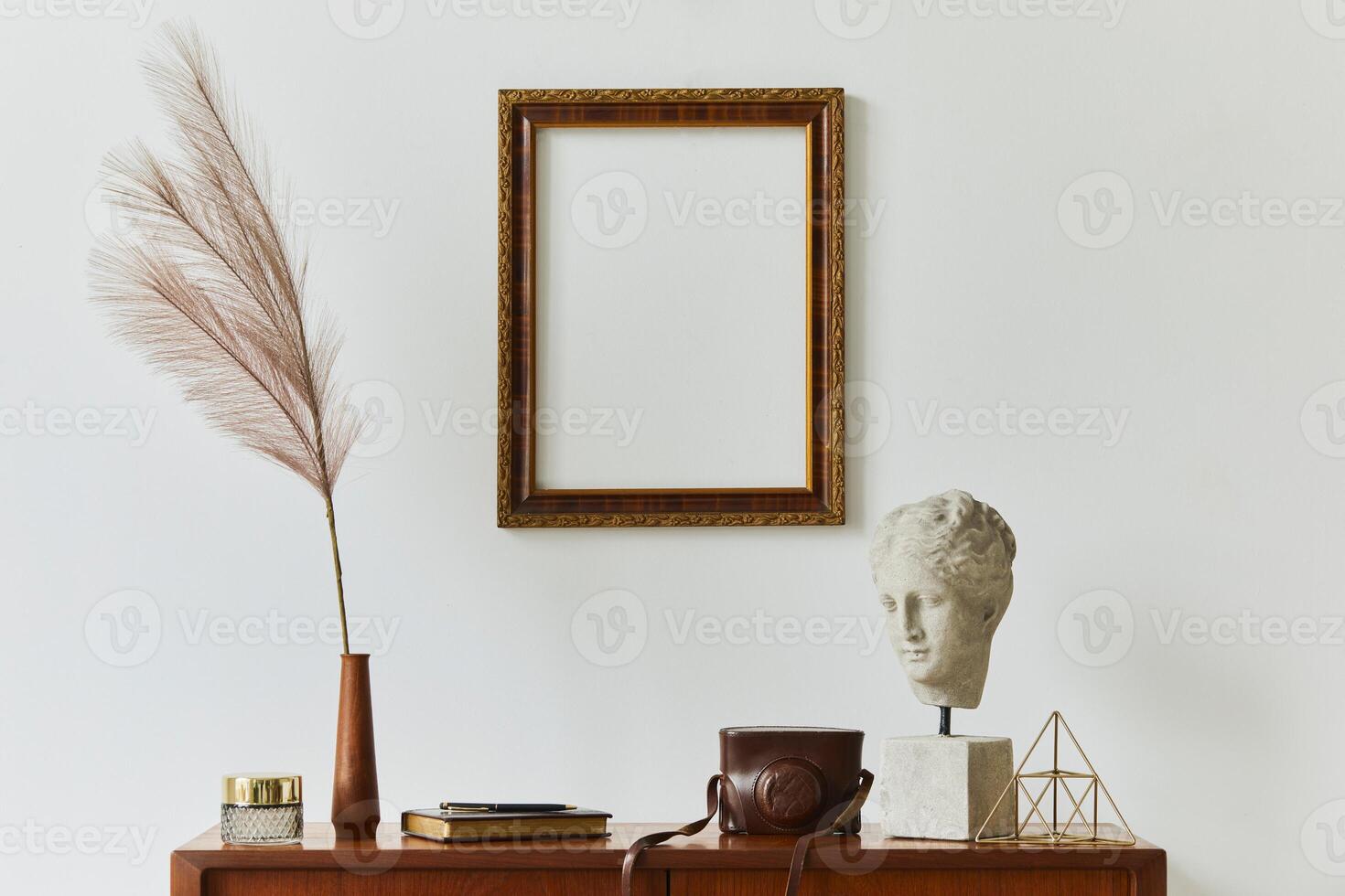 Stylish composition of artist workspace room with design retro teak commode, mock up poster frame, book, decoration and painting accessories. Template. photo