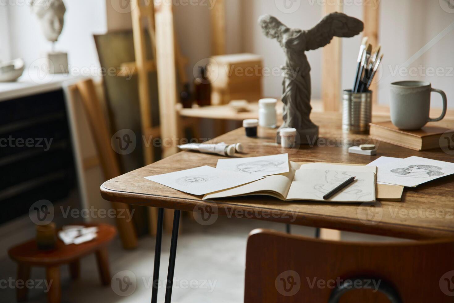 Unique artist workspace interior with stylish desk, wooden easel, bookcase, artworks, painting accessories, decoration and elegant personal stuff. Modern work room for artist. Template. photo