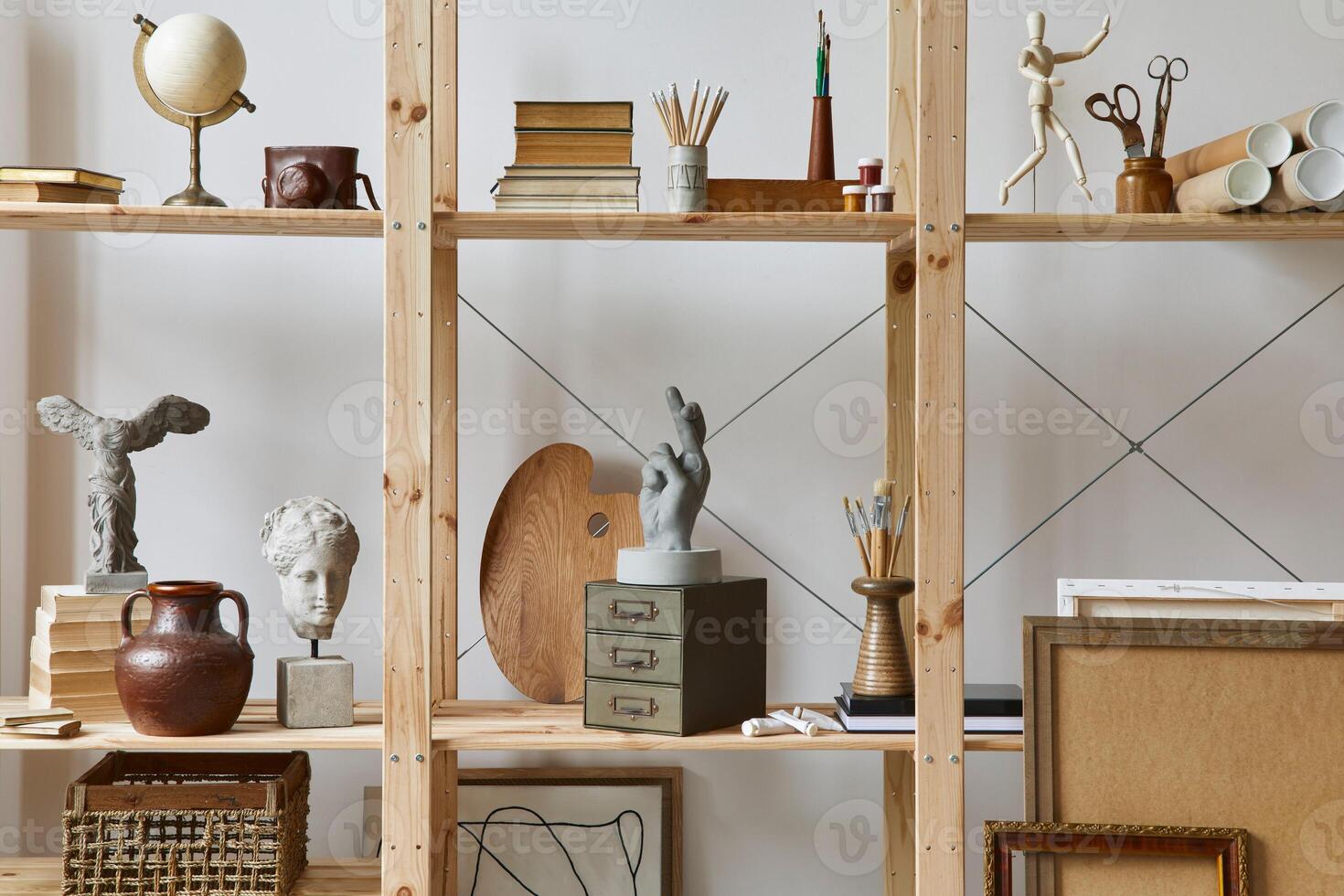Unique artist workspace interior with stylish desk, wooden easel, bookcase, artworks, painting accessories, decoration and elegant personal stuff. Modern work room for artist. Template. photo