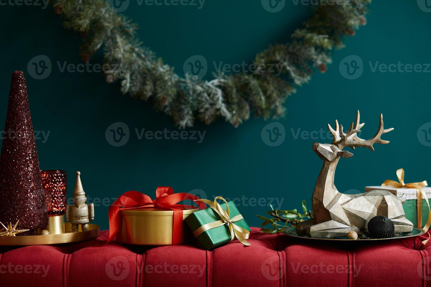 Christmas composition on the red velvet bench with decoration, gifts, wreath, lantern and accessories. Copy space. Red and green color. Template. photo