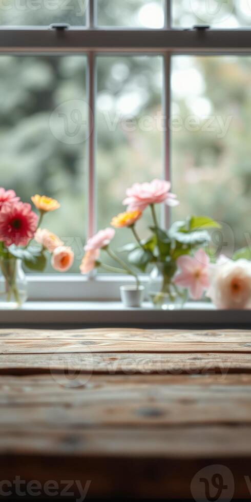 Colorful flowers in glass vases on a rustic wooden table with a serene garden view outside the window photo