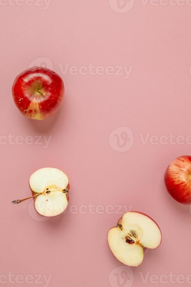 Red apple, half apple and quarter apple on pink background. Top view, healthy food concept. Top view. photo