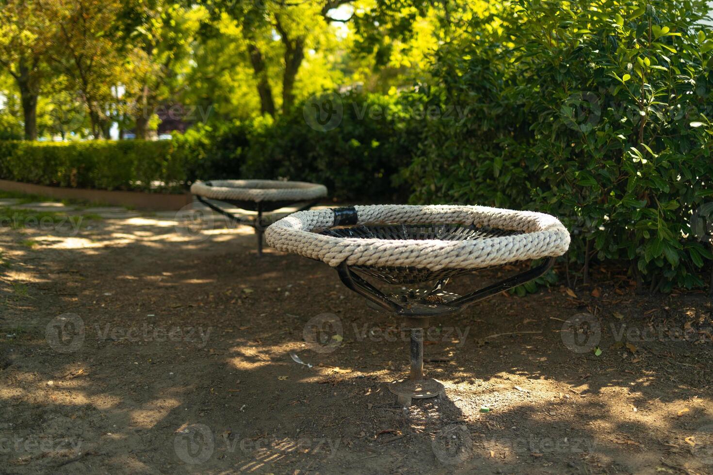 Black white rope circle swing seat at the playground close-up. Black net swing bench on a kids playground. Modern urban environment. photo