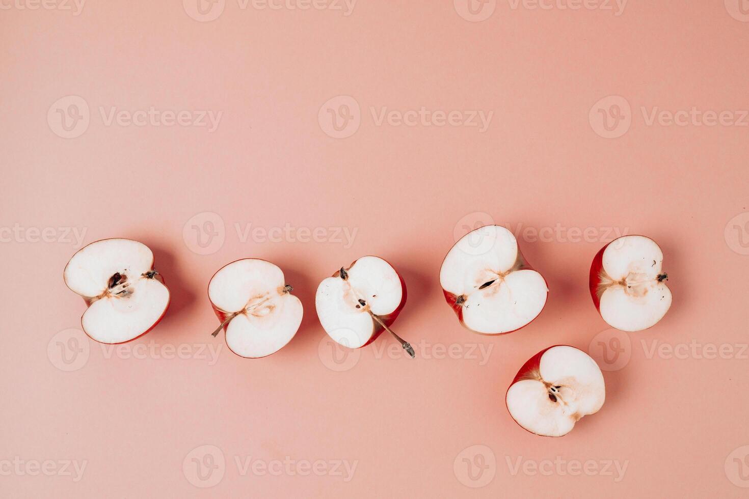 Red apple, half apple and quarter apple on pink background. Top view, healthy food concept. Top view. photo