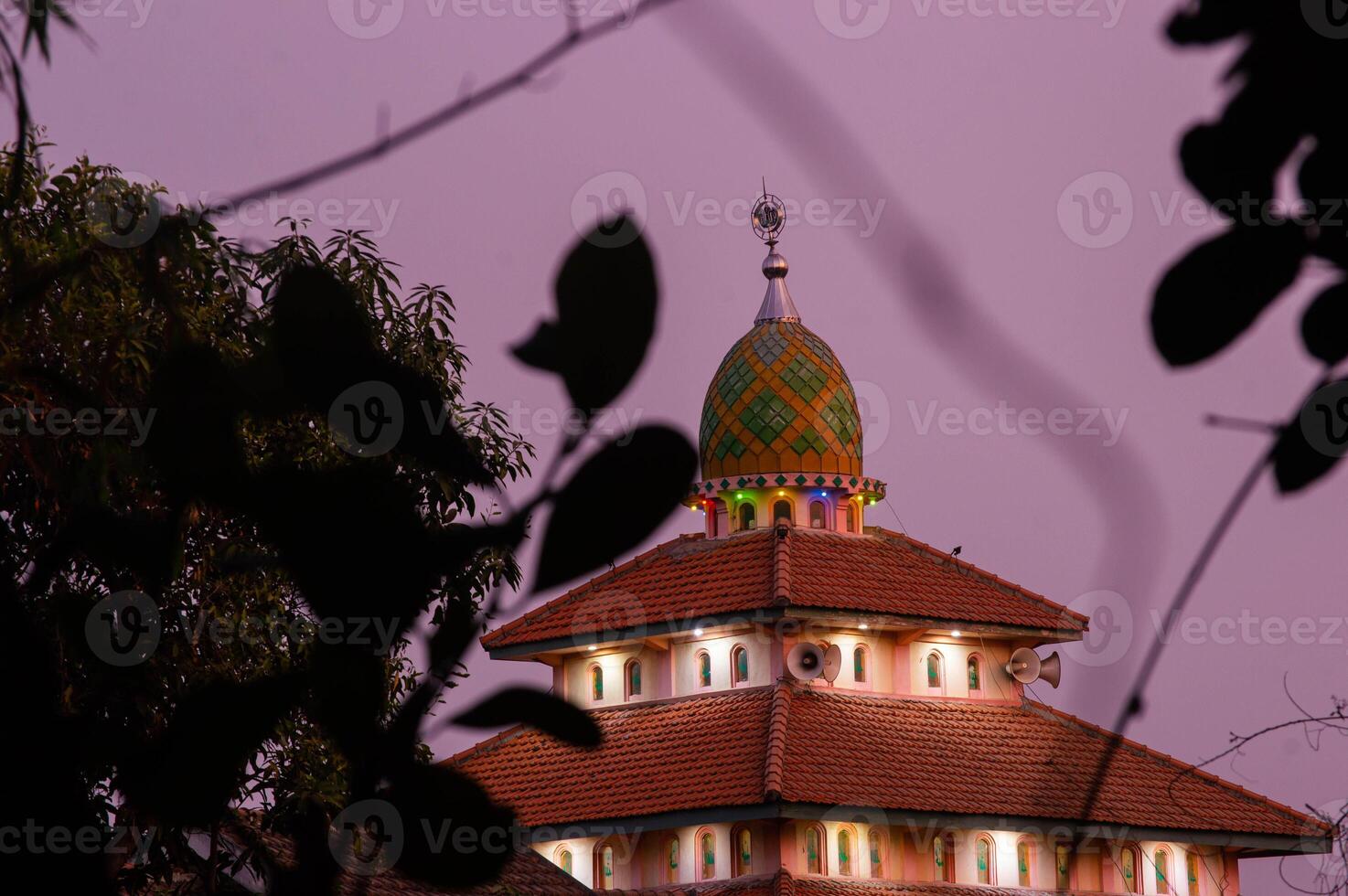 view of the mosque before sunset with the lights on photo