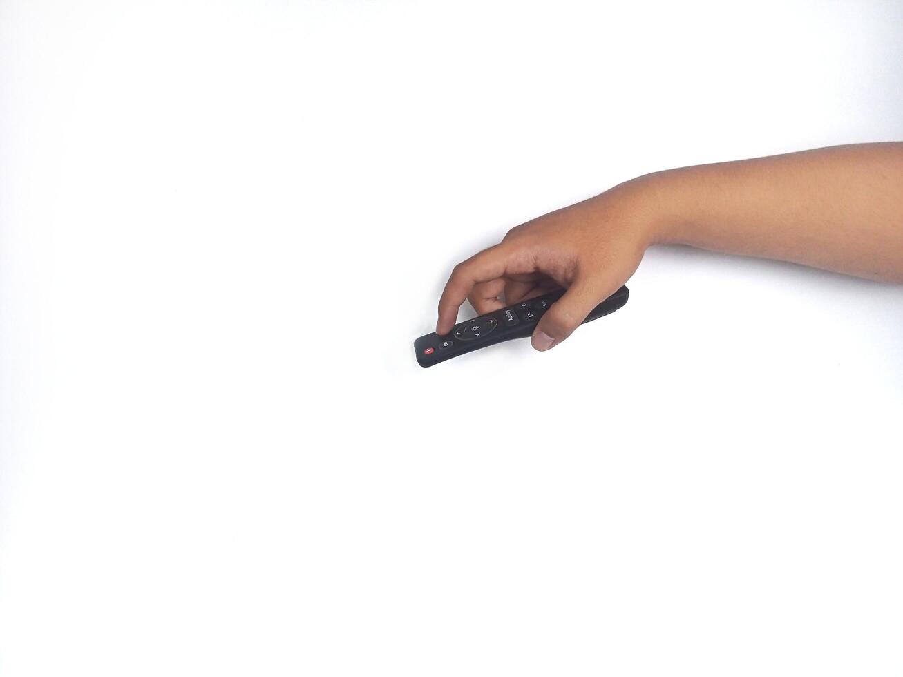 a hand holding a black remote control against a plain white background. The focus is on the remote, highlighting its buttons and ergonomic design. photo