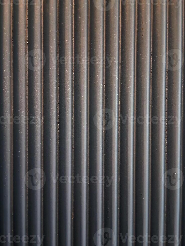 A photo of a background with a textured pattern of vertical lines in a dark neutral color.