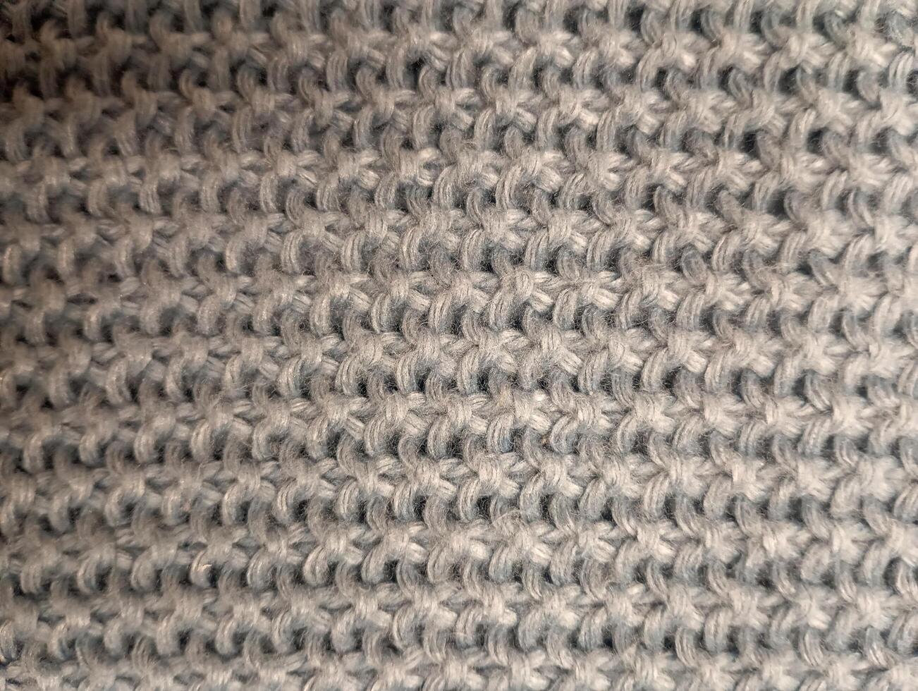 A photo of a textured knitted background in a neutral color.