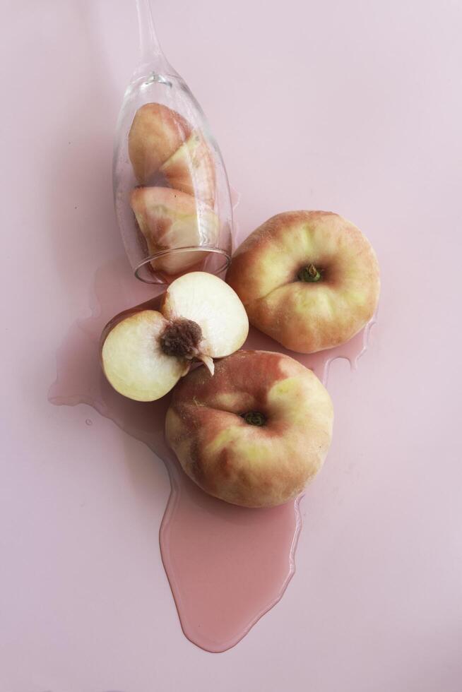 Doughnut Peach fruit with soft red orange peel put on pink background,b photo