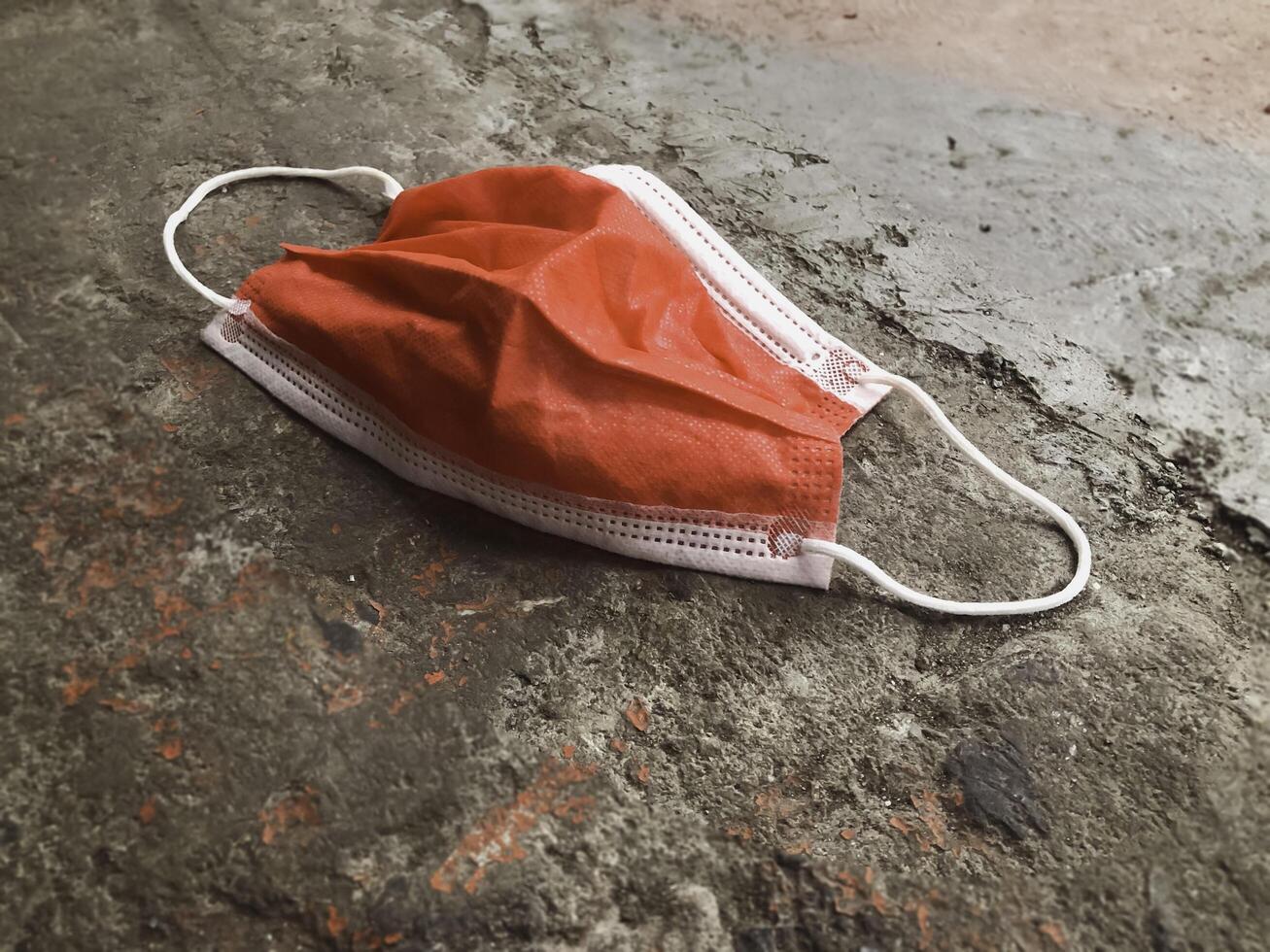 Clinical Mask fallen on grunge ground floor, photo