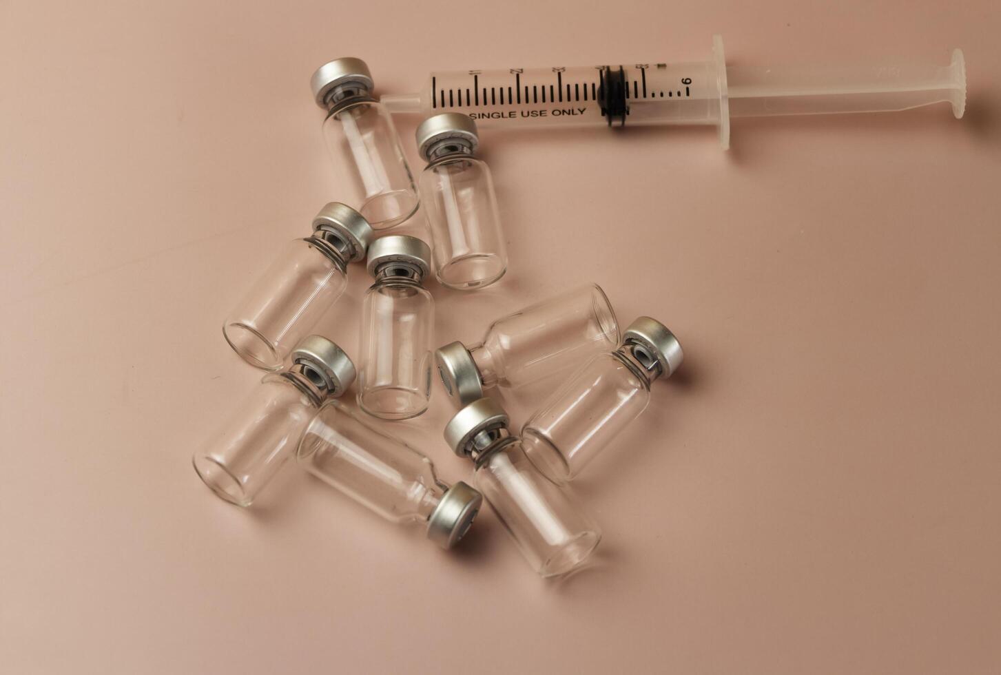 Syringe,vaccine bottles put on pastel background photo